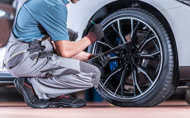 A technician inspects a tire.