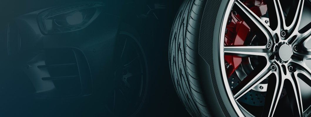 A tire for a vehicle rests against a wall.