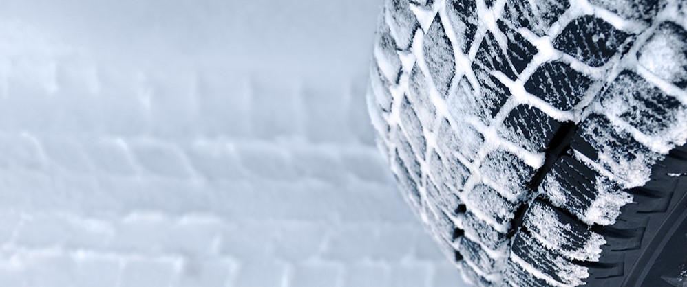 tire covered in snow showing its tracks on the ground